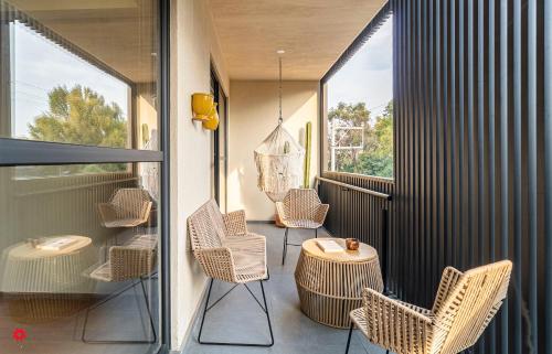 einen Balkon mit Korbstühlen und einem Tisch in der Unterkunft Casa Colima by Kukun in Mexiko-Stadt