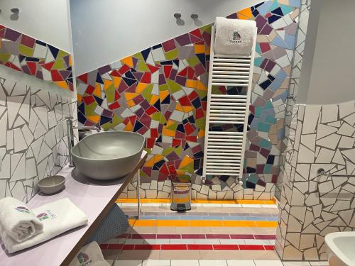 a bathroom with a colorful mosaic wall at VIANNA SUITES SPA in Lecce