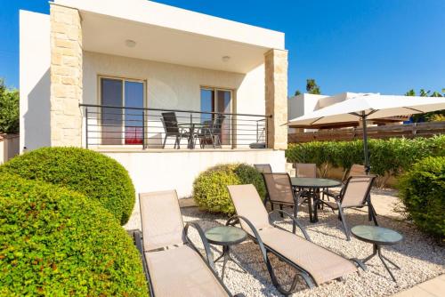 a patio with chairs and tables in front of a house at Villa Felice in Maa