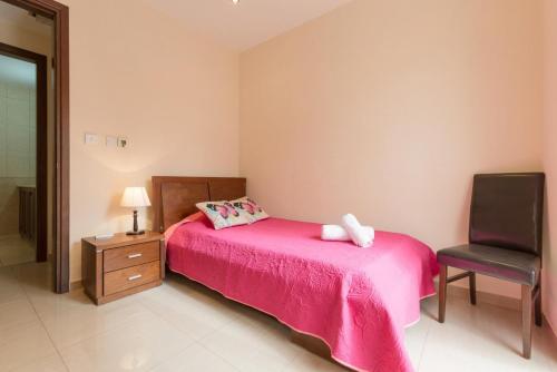 a bedroom with a pink bed and a chair at Villa Felice in Maa