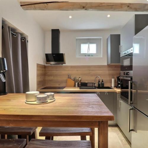 - une cuisine avec une table en bois et un comptoir dans l'établissement Le mas des glycines, à Salon-de-Provence