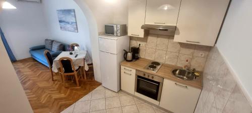 a small kitchen with a sink and a refrigerator at Apartments Tuzlak in Povile