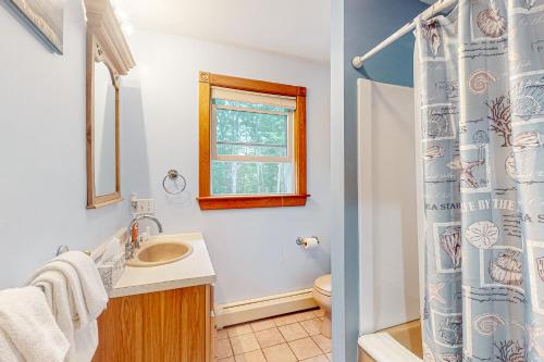 baño con lavabo y aseo y ventana en York's Beach Charmer, en York