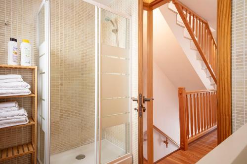 a glass shower in a bathroom with a staircase at Ca la Gloria in Vallcebre