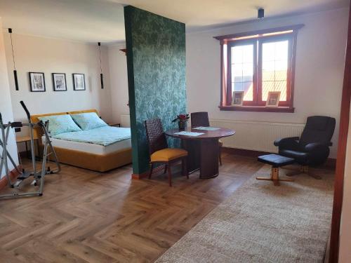 a bedroom with a bed and a table and a desk at Bed and Bread in Łeba