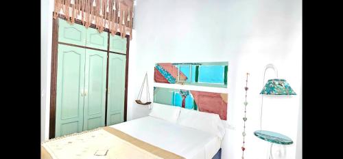a room with a bed and a green door at Casa Bakara Vejer old town in Vejer de la Frontera