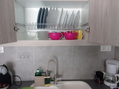 a kitchen counter with a sink and some bowls on a shelf at Pireas view in Piraeus