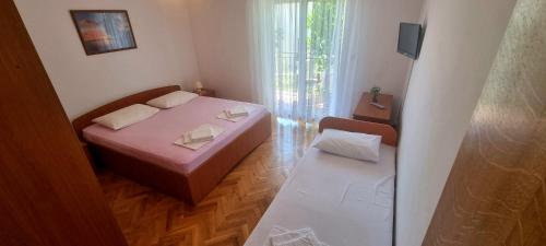a small room with a bed and a chair at Apartments Tuzlak in Povile