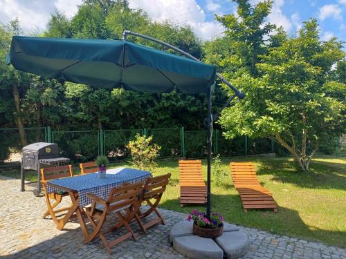 einen Tisch und Stühle mit Sonnenschirm im Hof in der Unterkunft Apartament LABA in Sosnowka