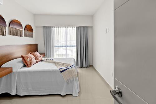 a bedroom with a bed and a window at Casa Barros Vacation Condos in Mazatlán