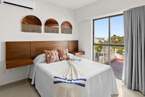 um quarto com uma cama e uma grande janela em Casa Barros Vacation Condos em Mazatlán