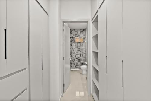 a white bathroom with a toilet and a hallway at Casa Barros Vacation Condos in Mazatlán
