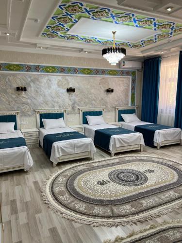 a room with four beds and a large rug at Diplomat Premium Hotel in Samarkand