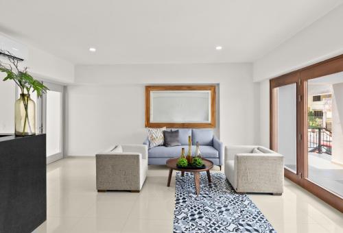 a living room with a couch and two chairs and a table at Casa Barros Vacation Condos in Mazatlán