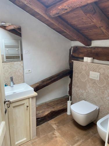 La salle de bains est pourvue de toilettes blanches et d'un lavabo. dans l'établissement L'Antico Borgo, à Zanica