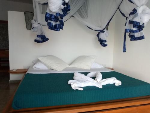uma cama com duas toalhas em cima em La Résidence Tiako em Ambondrona
