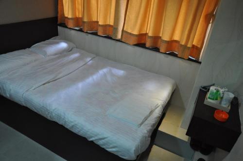 uma cama de hospital num quarto com janela em Blue Sky Hotel em Hong Kong