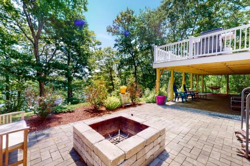 a patio with a fire pit and a deck at The Lakeside Landing in Plymouth