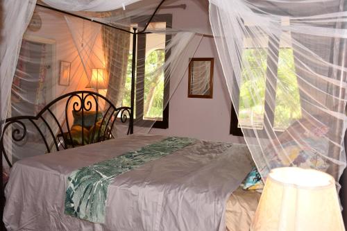 a bedroom with a bed with a canopy at King Room bed and breakfast main house in Tanetane