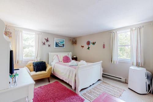 a bedroom with a white bed and a yellow chair at The Lakeside Landing in Plymouth