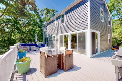 a patio with wicker chairs and a table on a deck at The Lakeside Landing in Plymouth
