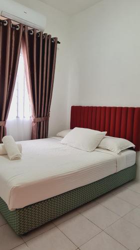 1 dormitorio con 1 cama con cabecero rojo y cortinas en Anjung KLIA House 72 With Neflix & Airport Shuttle en Banting