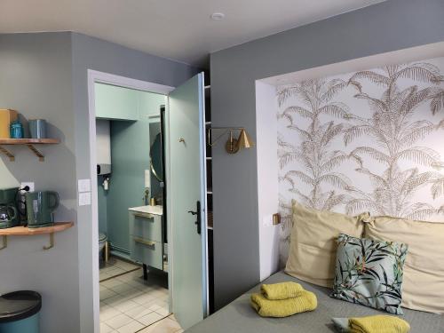 - une chambre dotée d'un lit avec un mur et un miroir dans l'établissement Ambiance raffinée cœur de ville, à Dijon