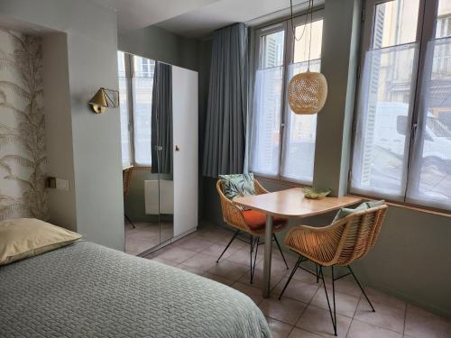 une chambre avec un lit, une table et des chaises dans l'établissement Ambiance raffinée cœur de ville, à Dijon