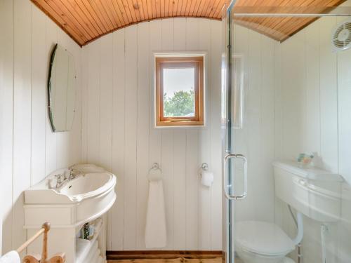 La salle de bains blanche est pourvue d'un lavabo et d'une douche. dans l'établissement Mahalia, à Fordham