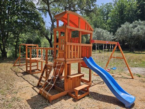 a wooden playset with a slide and a playground at Casa Toupeira 