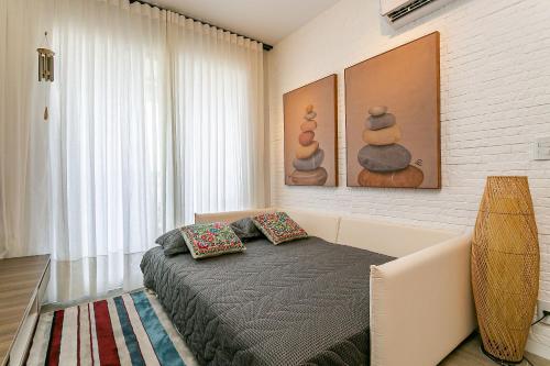 1 dormitorio con 1 cama con 2 almohadas en Apto no cond Thai Beach Home Spa frente mar TBS106, en Florianópolis