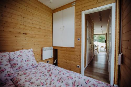 ein Schlafzimmer mit einem Bett und einer Tür, die zu einem Flur führt in der Unterkunft Kontenery Kapalica 