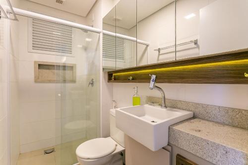 y baño con lavabo, aseo y ducha. en Apto no cond Thai Beach Home Spa frente mar TBS106, en Florianópolis