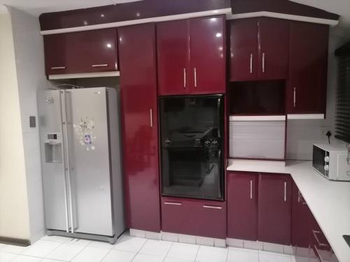 eine Küche mit roten Schränken und einem Kühlschrank in der Unterkunft Prosam Guesthouse Inn in New Germany