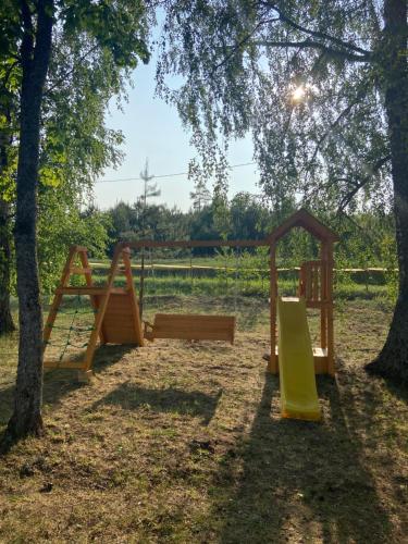 a group of wooden playground equipment in a park at Arkādija Krosts in Gaiduļi