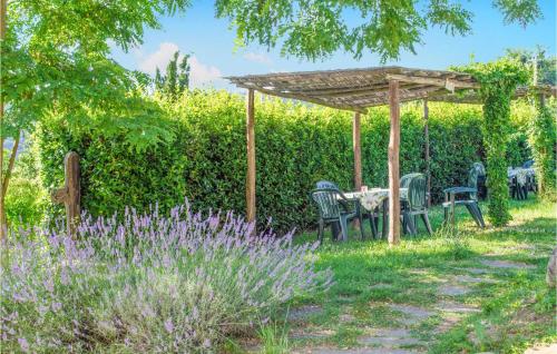 un jardín con mesa y sillas bajo una pérgola en Ginevra - Podere Moricci, en Montaione