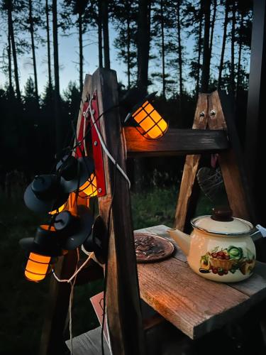 a wooden table with a lamp and a plate of food at Zarevo Glamping in Skobelevo