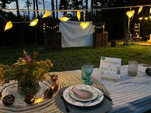 a picnic table with a plate of food and a sign at Zarevo Glamping in Skobelevo