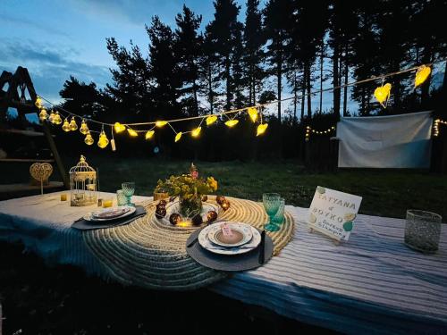 einen Tisch mit Teller mit Lebensmitteln und Lichtern drauf in der Unterkunft Zarevo Glamping in Skobelevo