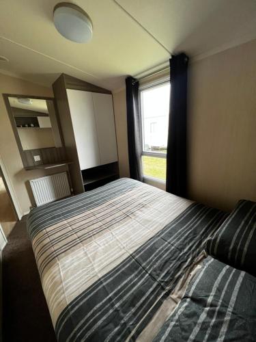 a bedroom with a large bed and a window at Aberlady75 in Port Seton