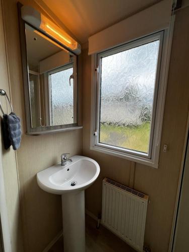 ein Bad mit einem Waschbecken und einem Fenster in der Unterkunft Aberlady75 in Port Seton