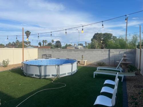 a backyard with a hot tub in the grass at Vic's 3 bedroom 4beds & POOL centrally located! in Las Vegas