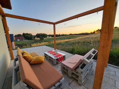 a patio with chairs and a table and a view of a field at Przystanek Dadaj in Najdymowo