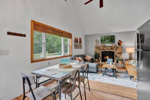 a kitchen and living room with a table and a fireplace at The Sage Chalet in Emerald Lakes, Poconos! in Long Pond