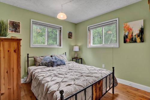 1 dormitorio con 1 cama y 2 ventanas en The Sage Chalet in Emerald Lakes, Poconos!, en Long Pond