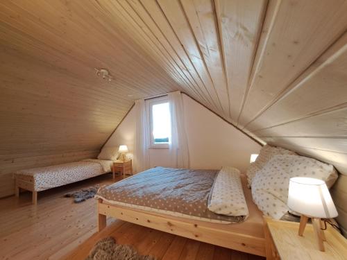 a bedroom with a bed in a wooden ceiling at Przystanek Dadaj in Najdymowo