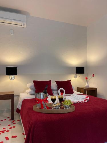 a red bed with a tray of food on it at Pousada 3 Bacias in Penedo