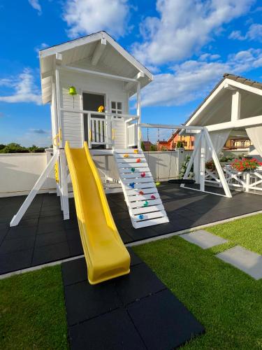 a playground with a slide and a house at Krystal Boutique Mansion in Hunedoara