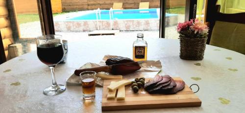 a table with a glass of wine and a plate of food at VIKENDICA NOLE Jahorina in Pale