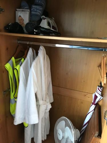 a closet with white towels and a fan at The Nook in Tawnyinah